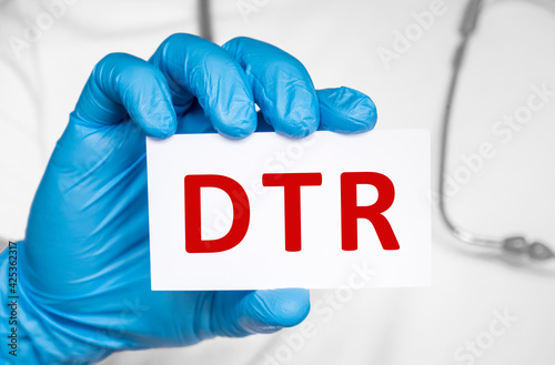 Doctor holding a card with text DTR Deep tendon reflexes, medical concept photo