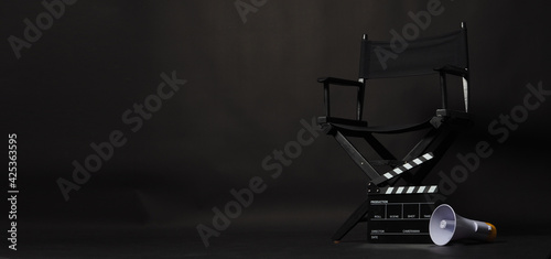 Black director chair and Clapper board or movie Clapperboard with megaphone on black background.use in video production or film cinema industry photo