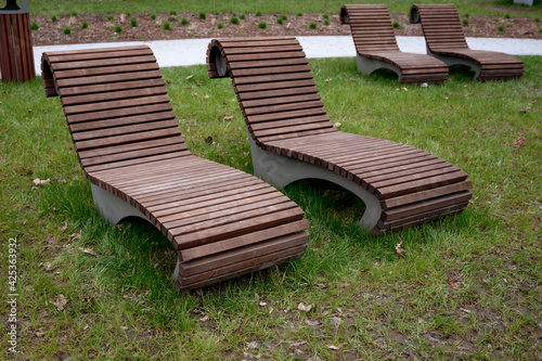 Fototapeta Naklejka Na Ścianę i Meble -  Bench in the park, wooden brown lounge chairs on the recreation area