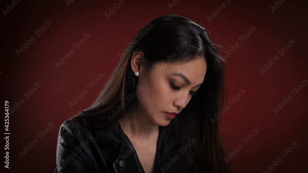 Young pretty woman in black leather jacket posing for the camera - studio photography