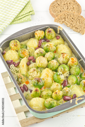 Brussels sprouts casserole with potatoes and kidney beans in cheese sauce