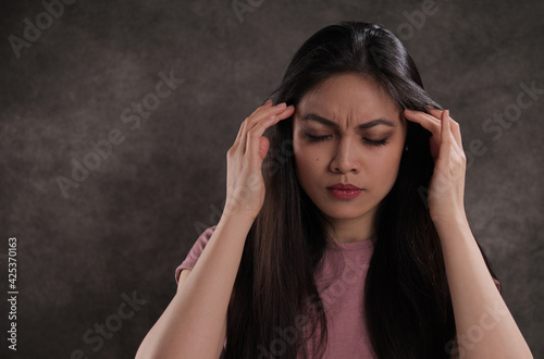 Young woman suffers from headache - studio photography