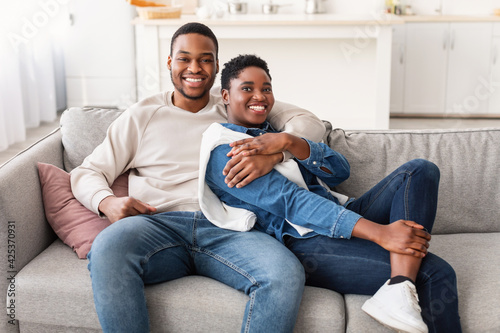 African american couple spending weekend together lying on couch © Prostock-studio