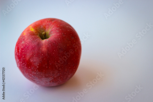 Red apple stand on a white surface