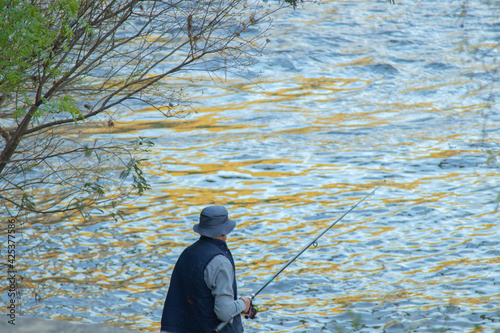 man with rod fishing in the river