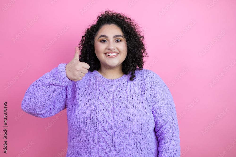 Young beautiful woman wearing casual sweater over isolated pink background success sign doing positive gesture with hand, thumb up smiling and happy. cheerful expression Young beautiful woman wearing casual sweater over isolated pink background success sign doing positive gesture with hand, thumb up smiling and happy. cheerful expression
