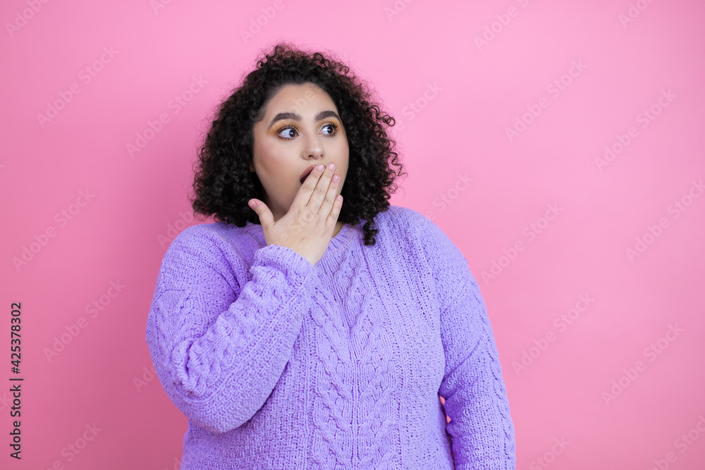 Young beautiful woman wearing casual sweater over isolated pink background covering mouth with hand, shocked and afraid for mistake. surprised expression Young beautiful woman wearing casual sweater over isolated pink background covering mouth with hand, shocked and afraid for mistake. surprised expression