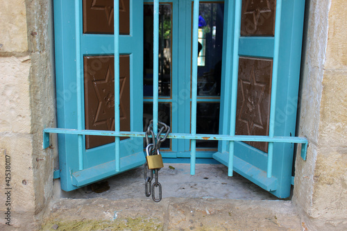 Peki'in. Israel. November 17, 2020. Peki'in is a Druze village in the northern region of Israel. Open window of a synagogue with blue shutters Peki'in. The lock on the grating in the window of the syn