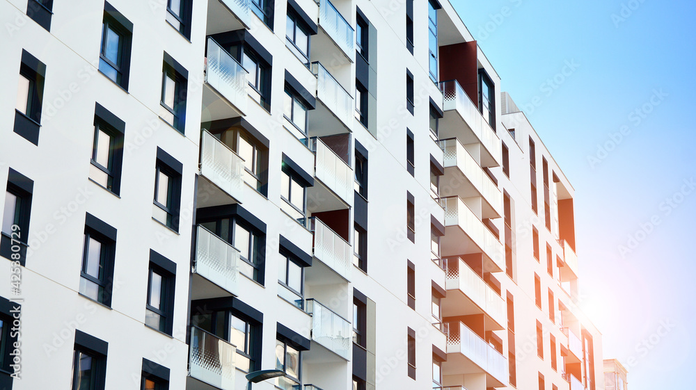 Facade of a modern apartment building. Glass surface with sunlight. Modern apartment buildings on a sunny day with a blue sky. Facade of a modern apartment building. Glass surface with sunlight. Modern apartment buildings on a sunny day with a blue sky.