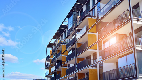 Facade of a modern apartment building. Glass surface with sunlight. Modern apartment buildings on a sunny day with a blue sky.