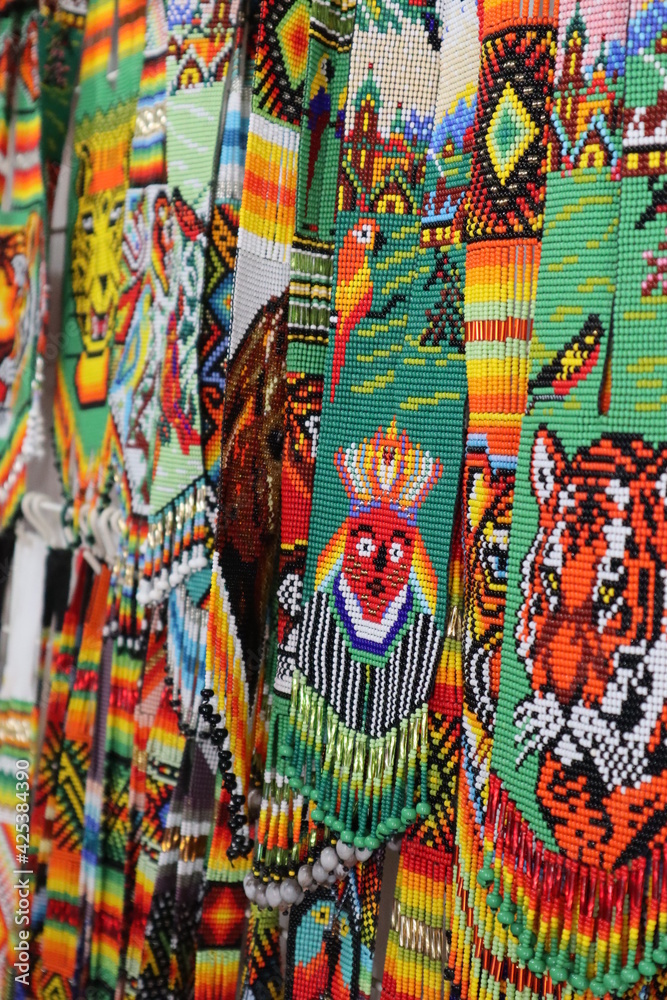 Naklejka premium Handmade indigenous jewellery with colorful pearls from the amazonas, with animals and symbols from his cosmovision