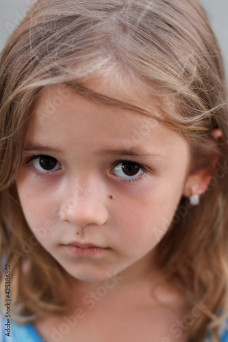  portrait of a little girl with dark sad eyes