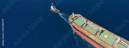 Aerial drone ultra wide photo of huge crude oil tanker ship guided by tug boats © aerial-drone