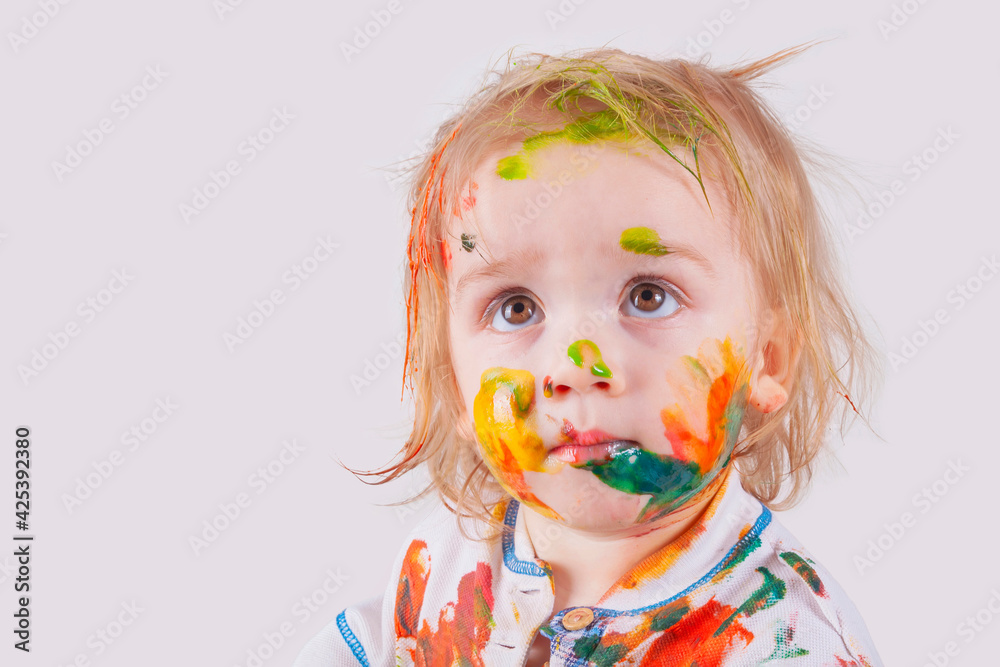 The child messy painted his face and clothes with paint. Children's pranks. The child messy painted his face and clothes with paint. Children's pranks.