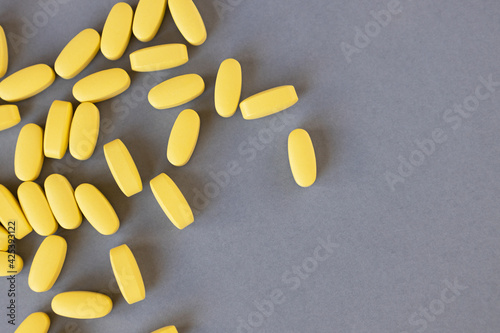 Wallpaper Mural Yellow long vitamins or pills on a gray background, closeup, mock up, copy space. Nutritional supplements concept, health, vitamins, trendy colors of 2021, Illuminating, Ultimate Gray. Horizontal Torontodigital.ca