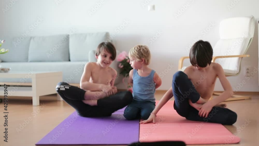 Children, making exercises at home in sunny room, making lotus flower exercise and staying fit