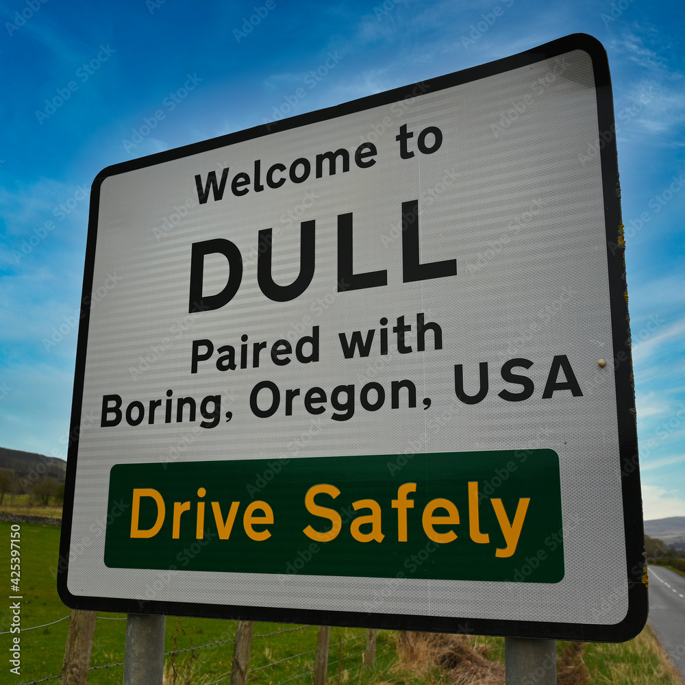 Dull paired with Boring road sign in Perthshire, Scotland. Vibrant, colourful background of blue sky and green countryside.