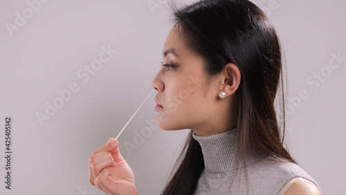 Young woman performs a Covid-19 antigen self-test - studio photography