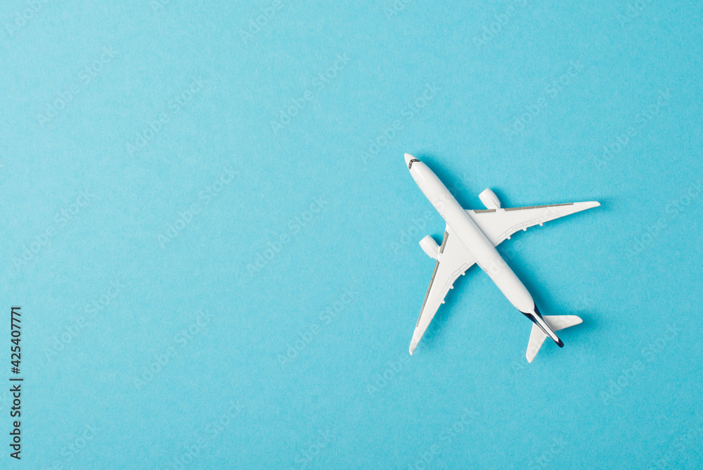 Top view photo of white airplane model on isolated pastel blue background with copyspace Top view photo of white airplane model on isolated pastel blue background with copyspace