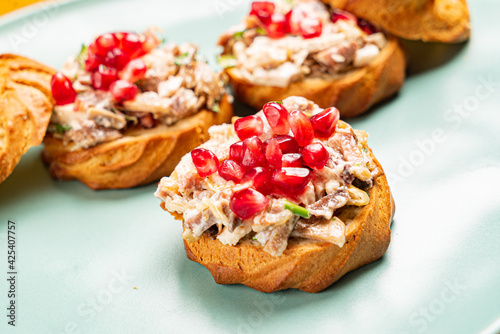 canape with meat salad and pomegranate seeds
