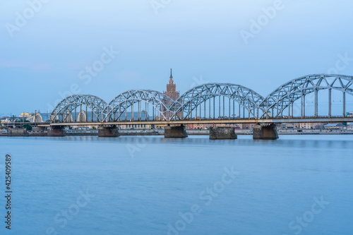 Cityscape with Railway Bridge in Riga, Latvia, on Blue Hour over River Daugava