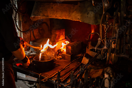 Professional blacksmith working with metal quenching hot iron part with water at forge. Handmade, craftsmanship and blacksmithing concept blacksmith quenches finished steel in Forge
