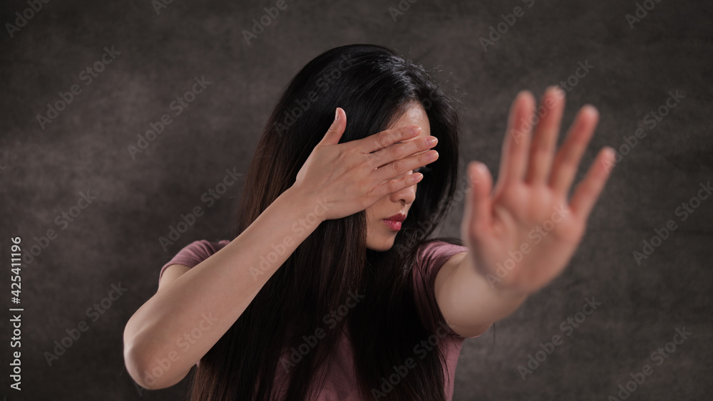 Young woman does not want to be photographed - studio photography Young woman does not want to be photographed - studio photography