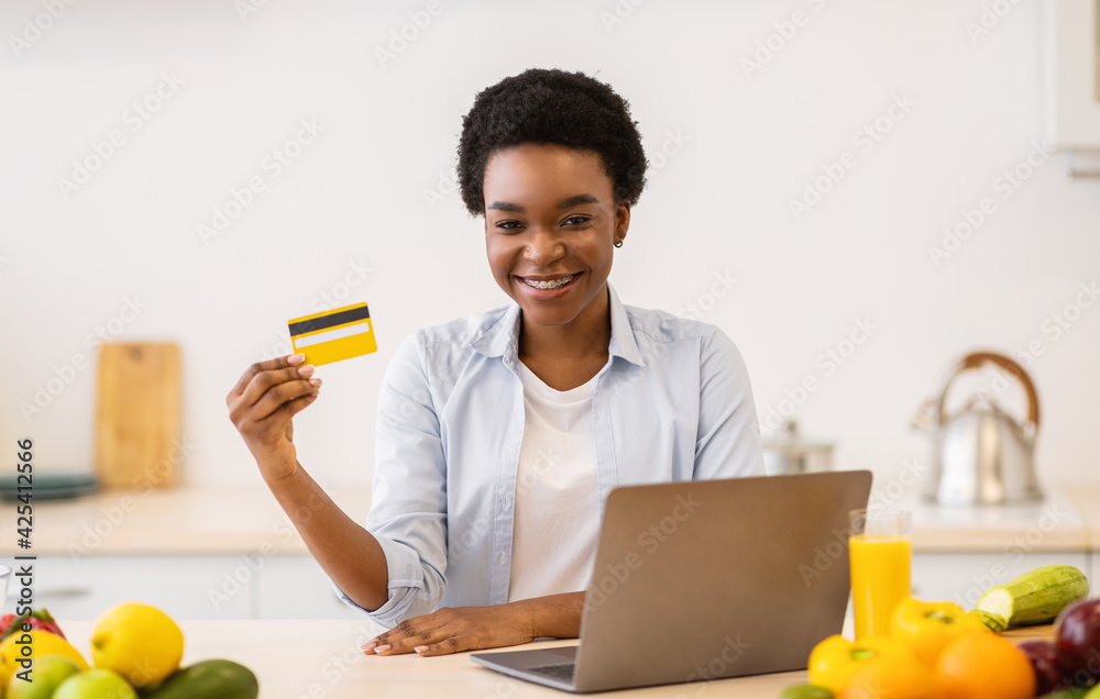 Lady Doing Grocery Shopping On Laptop, Showing Credit Card Indoor Lady Doing Grocery Shopping On Laptop, Showing Credit Card Indoor