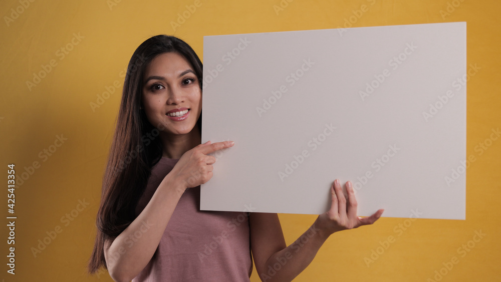 Young pretty woman holds a sign mock-up - studio photography Young pretty woman holds a sign mock-up - studio photography