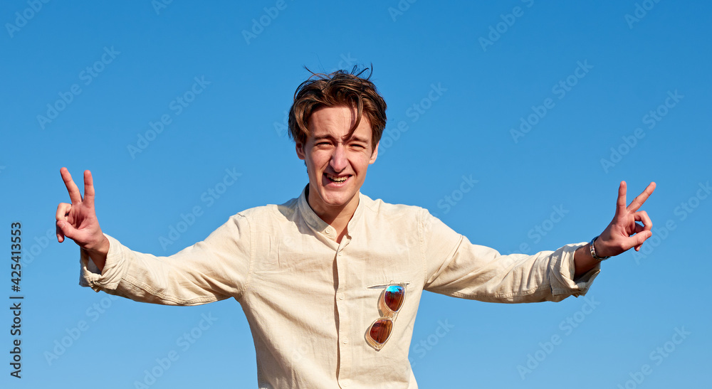 A Caucasian man from Spain making victory signs with both hands on clear sky background A Caucasian man from Spain making victory signs with both hands on clear sky background