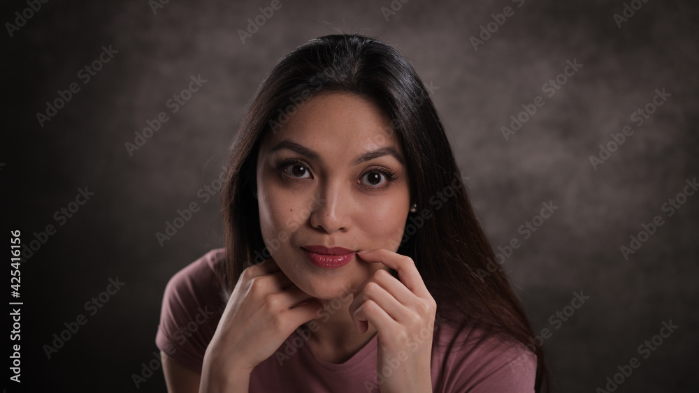 Close-up of a young woman with a satisfied facial expression - studio photography Close-up of a young woman with a satisfied facial expression - studio photography