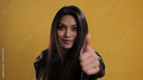 Young confident woman with thumb-up gesture - studio photography
