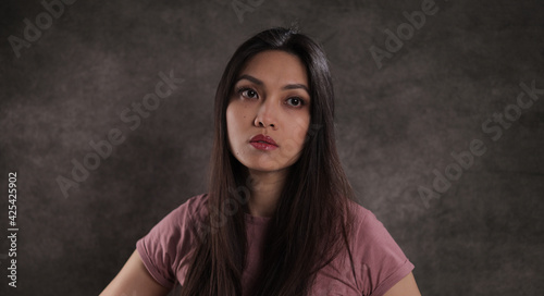 Pretty Asian woman against a grey background - studio photography