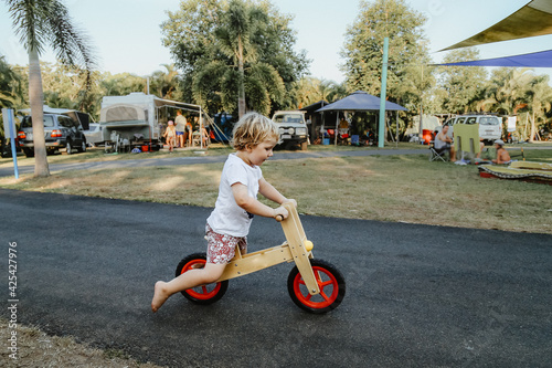 Little boy riding balance bike while on holidays at caravan park photo
