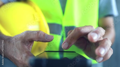 Close up construction worker touch screen on smart phone