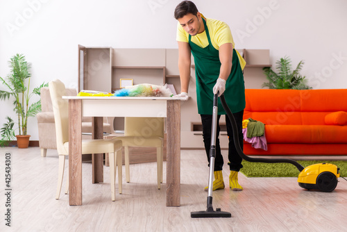 Young male contractor cleaning the house indoors