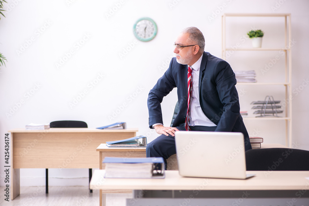 Old businessman employee sitting in the office Old businessman employee sitting in the office