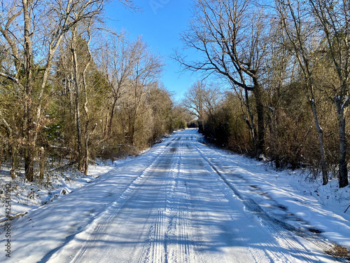 A cold country road extends into the distance after a snow storm