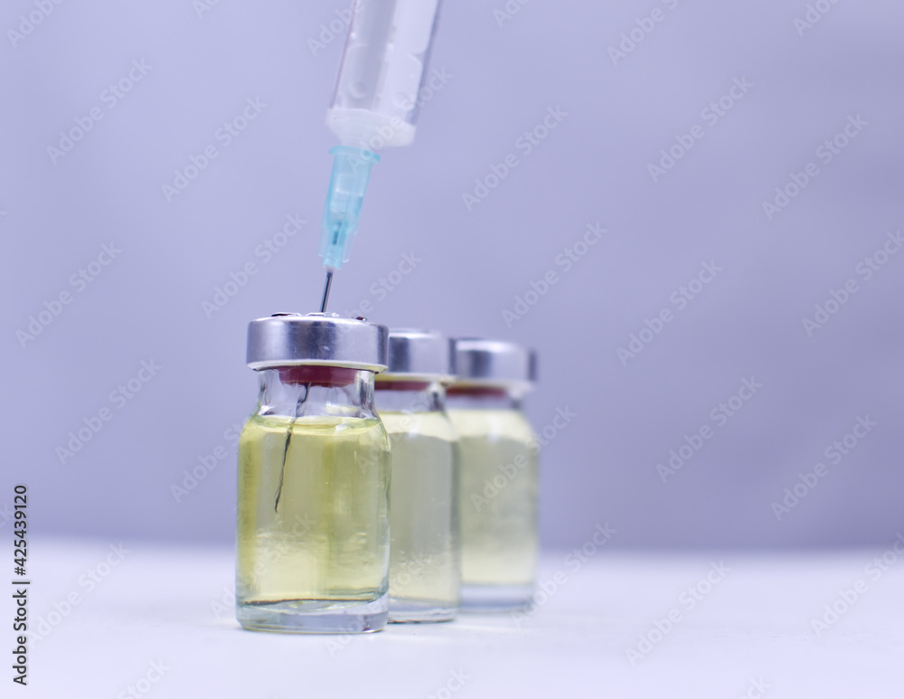Vial of drugs injection or vaccine with syringe needle on a white background for cure and prevention of sickness Vial of drugs injection or vaccine with syringe needle on a white background for cure and prevention of sickness