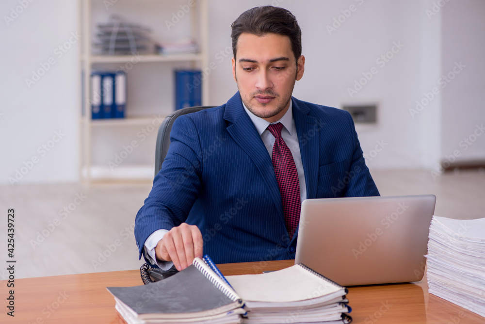 Young businessman and too much work in the office Young businessman and too much work in the office