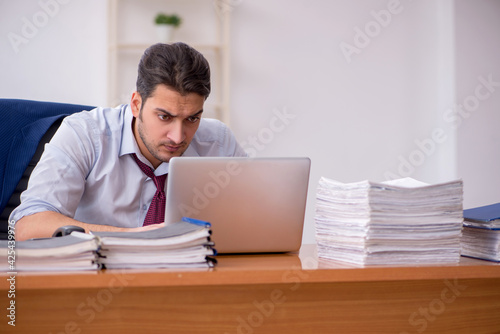 Young businessman and too much work in the office