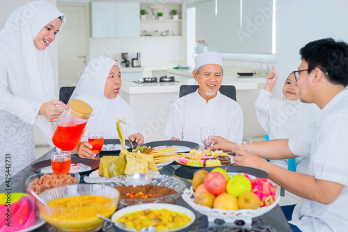 Muslim woman serving fresh drink to her family