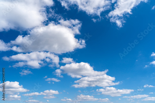 Blue sky with beautiful white soft clouds. Full frame background on a sunny day. Cloudscape in the nature heaven. Abstract photo of summer weather.