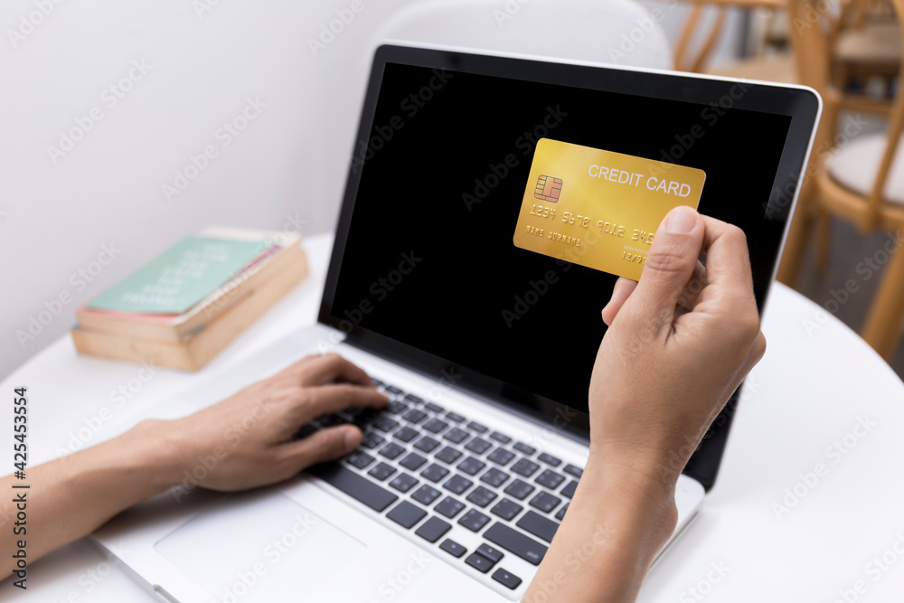 Woman holding credit card and using laptop computer. Women working at home. Online shopping, e-commerce, internet banking, spending money, working from home concept. Technology shopping online concept Woman holding credit card and using laptop computer. Women working at home. Online shopping, e-commerce, internet banking, spending money, working from home concept. Technology shopping online concept