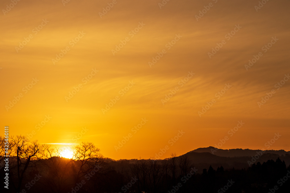 山に沈む夕日　夕焼け　太陽　空　木のシルエット