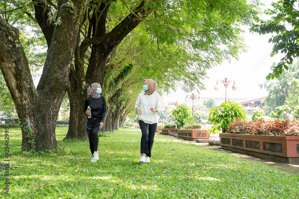 Fototapeta premium two muslim woman friend jogging together and wear a mask for virus covid protection