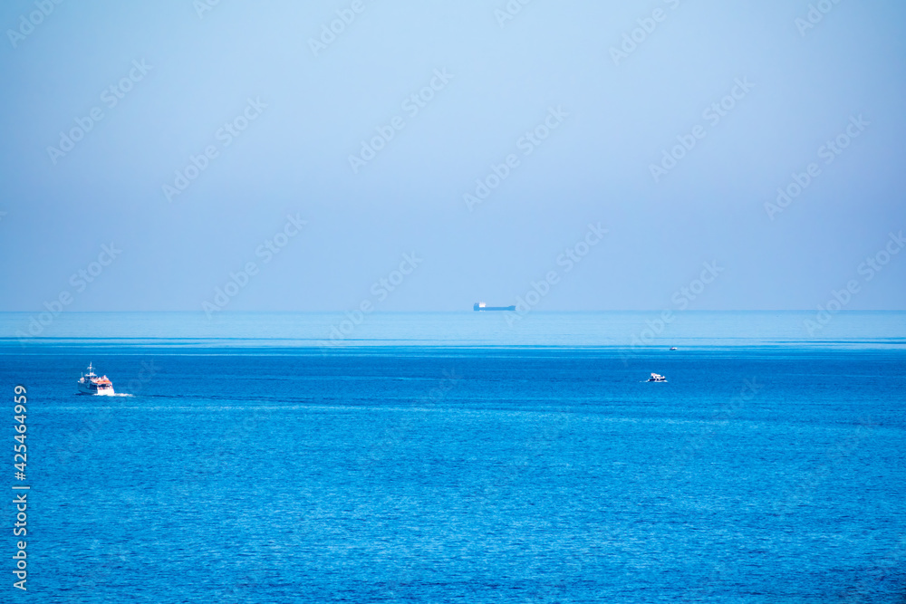 Several ships in the blue calm sea.