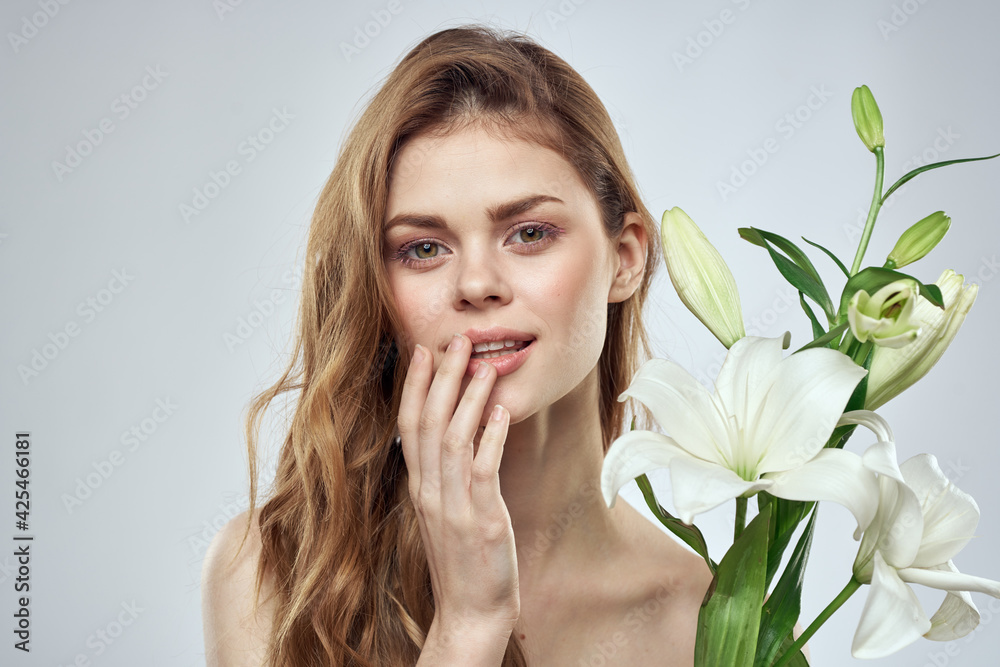 Emotional woman with flowers spring model naked shoulders clear skin Emotional woman with flowers spring model naked shoulders clear skin