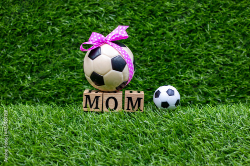 Soccer Mother's Day with ball and word mom on green grass © thaninee