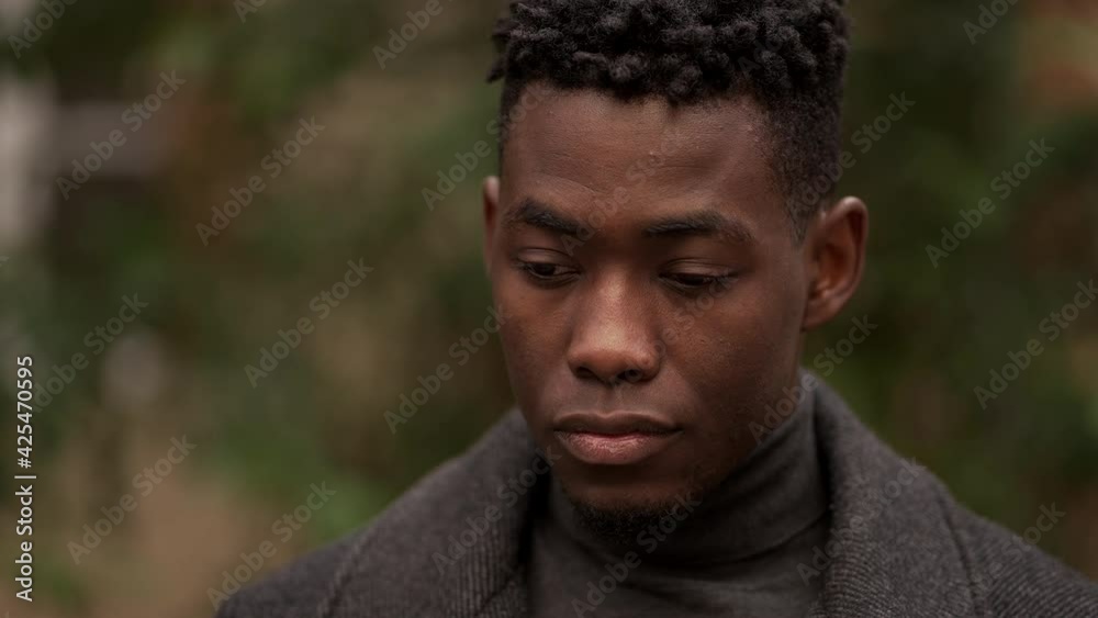 Contemplative young black man in meditative expression outside, close-up face Contemplative young black man in meditative expression outside, close-up face